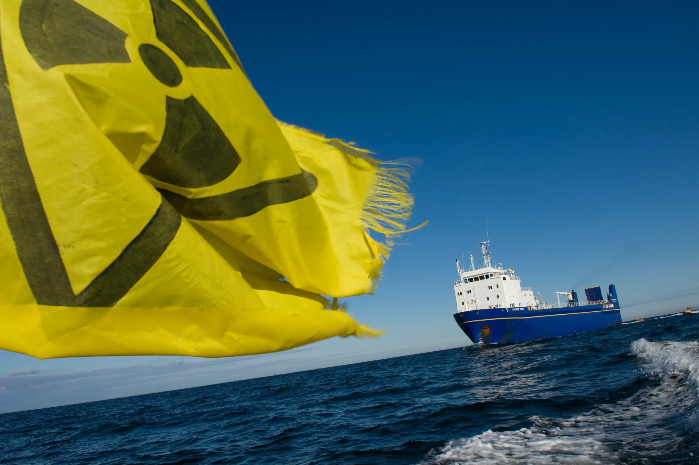 Large yellow flag in foreground with ship in the background on the water