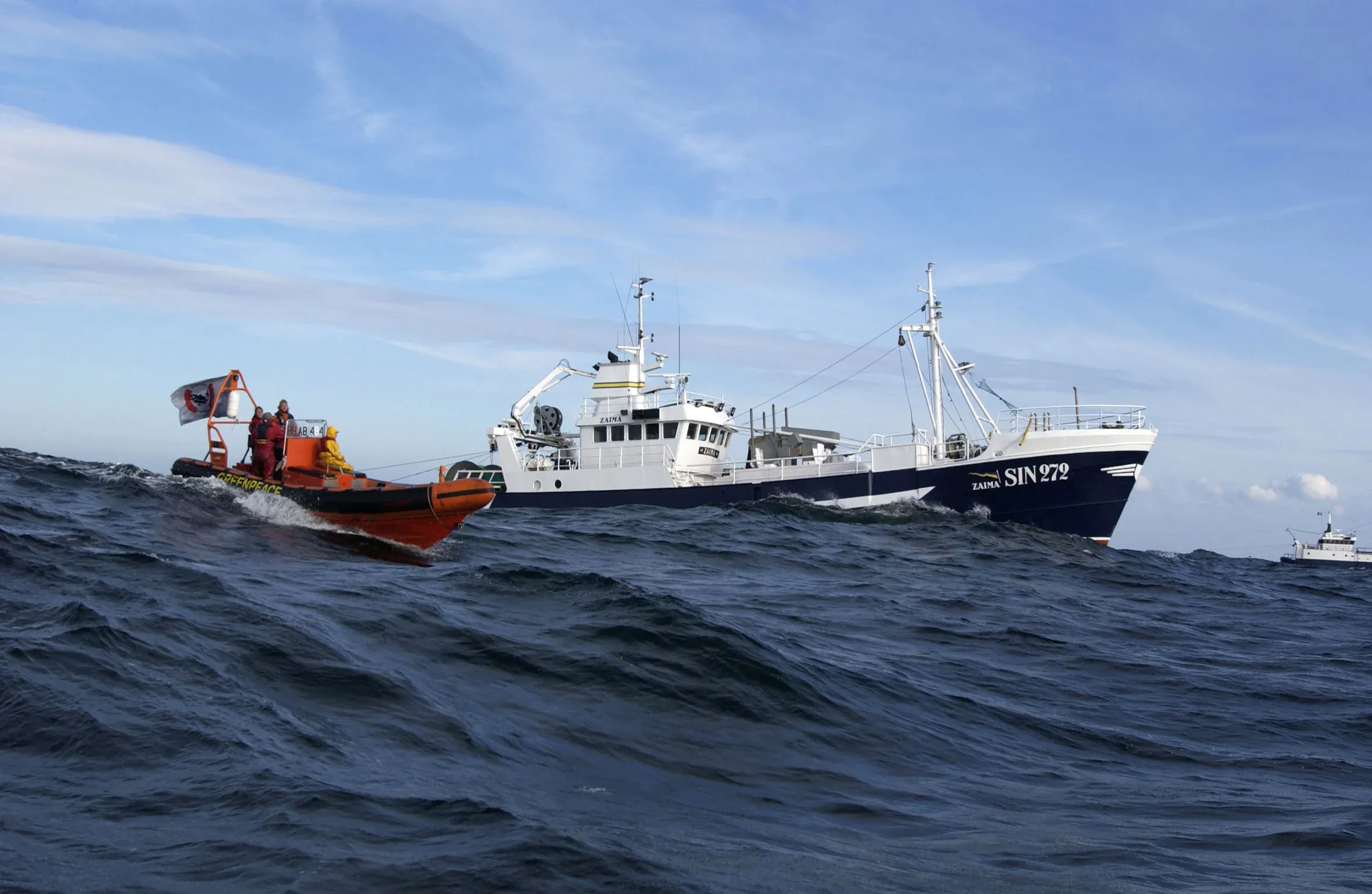 High-speed patrol boat in front of a military vessel during a maritime training exercise